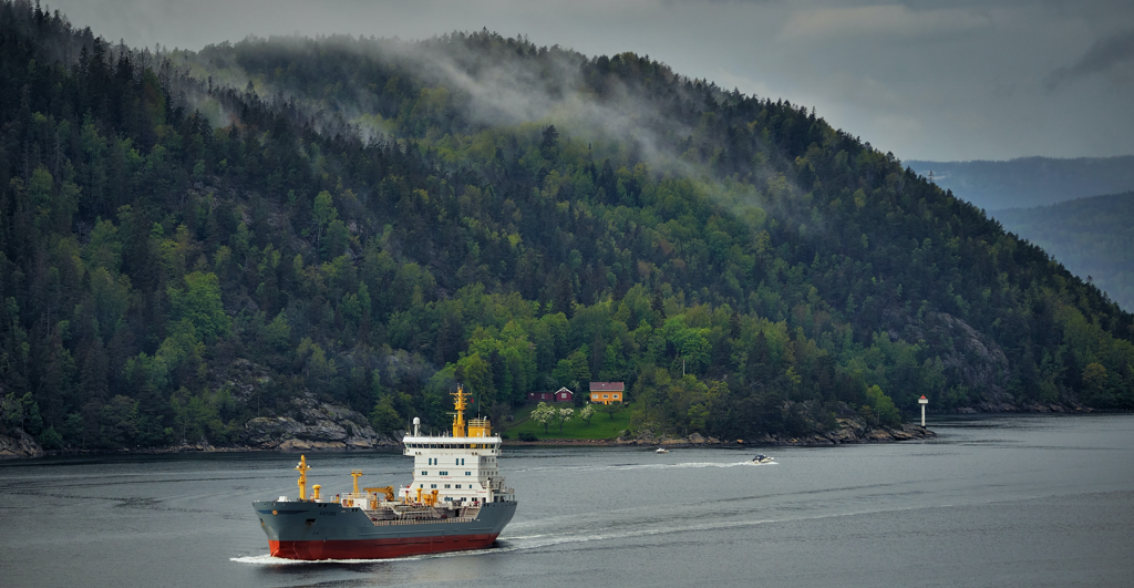 Ship near a wooded hillside